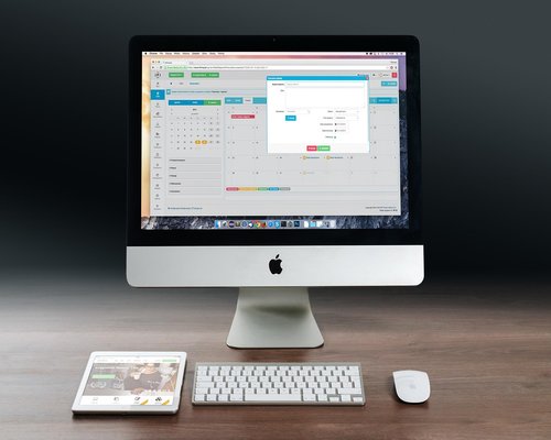 Clean and minimalist white desk setup with an Apple iMac and simple decor